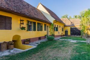 an old house with yellow walls and a yard at Șura din Seleuș - Seleuș Barn - Idyllic Countryside M Museum House in Sighişoara +44 photos