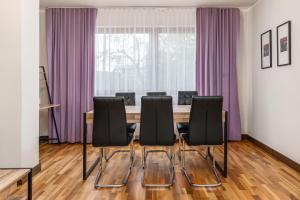 コウォブジェクにあるJantar Apartamenty Deluxe Royal Tulip Sand Hotelのカンファレンスルーム(テーブル、黒い椅子付)