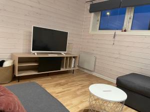 a living room with a flat screen tv on a stand at Spacious 50 sqm apartment close to city centre! in Tromsø