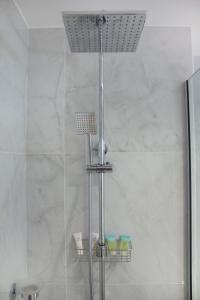 a shower with a glass door in a bathroom at LUXE Studio Near Discovery Gardens Metro Station in Dubai