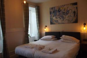 a bedroom with a bed with two towels on it at The Liverpool Arms Hotel in Beaumaris