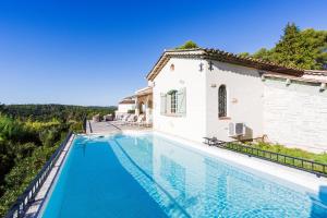 a villa with a swimming pool next to a house at Villa Les Feuillets VI4250 by Riviera Holiday Hom in Roquefort-les-Pins