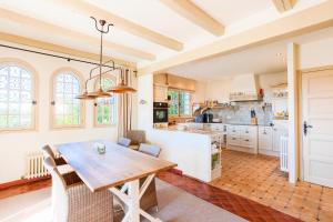 a large kitchen with a wooden table and chairs at Villa Les Feuillets VI4250 by Riviera Holiday Hom in Roquefort-les-Pins