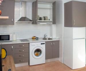 uma cozinha com uma máquina de lavar roupa e um lavatório em Bonito apartamento en Garrucha em Garrucha
