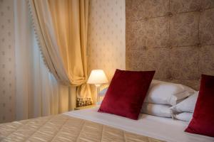 a bedroom with a bed with two red pillows at Albergo Rossini 1936 in Bologna +125 photos
