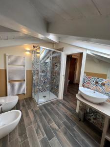a bathroom with two sinks and a glass shower at Osteria Senza Fretta Rooms for Rent in Cuneo