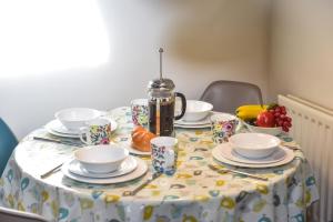 a table with cups and saucers on top of it at Church Farm Holiday Cottages - Winnets Cottage in Ashbourne