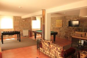 een woonkamer met een pooltafel en een piano bij Meiros House Tourism and Nature in Amares