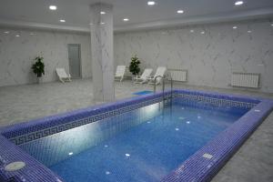 a large swimming pool in a room with chairs at Гостиничный комплекс Коктобе in Aktobe