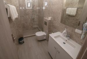 a bathroom with a shower and a toilet and a sink at Apartments Serxhio in Sarandë +43 photos