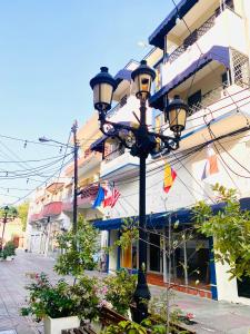 uma luz de rua em frente a um edifício com bandeiras em RIG Casa Conde em Santo Domingo