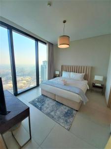 a bedroom with a large bed with a large window at Luxury at The Address Jumeirah Beach Residence in Dubai