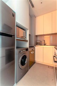 a kitchen with a stainless steel washer and dryer at Luxury at The Address Jumeirah Beach Residence in Dubai