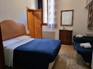 een slaapkamer met een blauw bed en een spiegel bij Alloggi alla Scala del Bovolo in Venetië