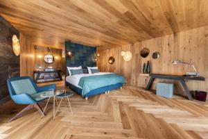 una camera con letto e soffitto in legno di Hotel Fanes a San Cassiano