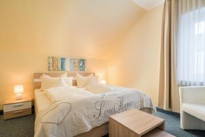 een slaapkamer met een groot wit bed met een bordje erop bij Arador-City Hotel in Bad Oeynhausen