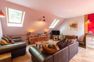 a living room with a couch and a tv at The Beeches Studio, Highlands of Scotland in Newtonmore