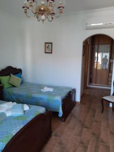 a room with two beds and a chandelier at MARIA INÊS HOUSE in Nazaré