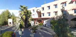 ein großes weißes Gebäude mit Bäumen davor in der Unterkunft Apartamentos Serrallo, Parking gratuito y cocina, Alhambra y playa in Granada