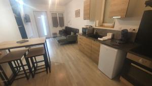 a kitchen and living room with a counter and a table at Maison de charme pour 6 au coeur de l'Auvergne in Brassac-les-Mines