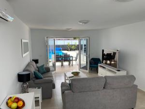 un soggiorno con divano e tavolo di Villa Ashdene - luxury modern villa with large heated pool wifi uk tv bar & BBQ a Playa Blanca