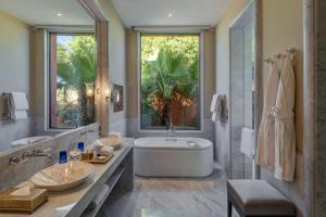 a bathroom with a tub and a large window at The Oberoi Marrakech in Marrakech