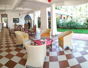 a patio with chairs and a table and a table at Bluesea Beach Resort in Candolim