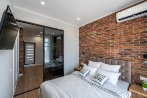 a bedroom with a brick wall and a bed at Стильная квартира с балконом на 5 Фонтана in Odesa
