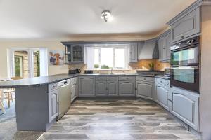 a kitchen with white cabinets and a large island at Host & Stay - Highfield in Newton on the Moor