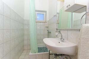 a white bathroom with a sink and a shower at House Nikola in Tučepi +11 photos