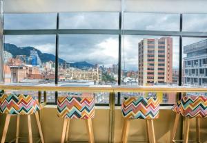 a view of a city skyline from a bar with stools at Hotel Express 53 in Bogotá