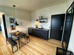 a kitchen with a table and a sink at Broncks Apartment 4 - Modern 1-Bedroom in the Heart of Tórshavn in Tórshavn