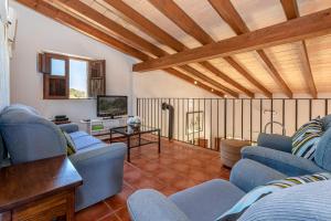 sala de estar con sofás azules y TV en VILLA CAL MERCADER, en Alcudia
