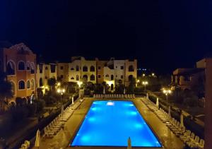 a large swimming pool in front of a building at night at Basilicata Host to Host - BORGO SAN BASILIO in Marina di Pisticci
