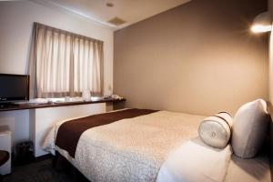 a hotel room with a bed and a television at Kakegawa Station Hotel in Kakegawa +18 photos
