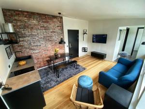 a living room with a blue couch and a brick wall at Broncks Apartment 2 - Modern 2-Bedroom in the Heart of Tórshavn in Tórshavn