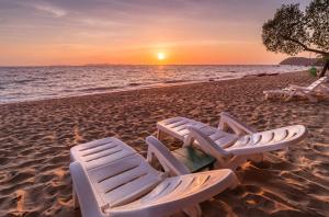 2 Liegestühle am Strand bei Sonnenuntergang in der Unterkunft Koh Jum Ocean Beach Resort in Ko Jum