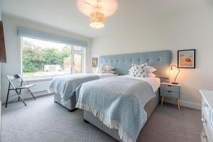 two beds in a bedroom with a window at Festival House, Snape in Saxmundham