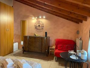 a living room with a red chair and a table at Bed&Breakfast Milano Malpensa in Busto Arsizio