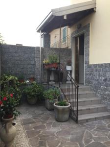 a house with stairs and potted plants in front of it at Bed&Breakfast Milano Malpensa in Busto Arsizio