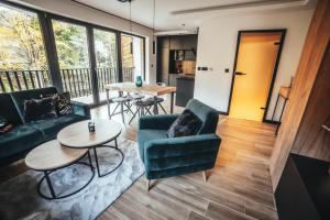 a living room with a couch and a table at CZARNA OWCA Apartament - SKRZYCZNE Residence in Szczyrk