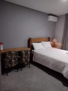a bedroom with a bed and a nightstand and a bed sidx sidx sidx sidx at Armazém do Porto, Chalé Azaléia in Morretes