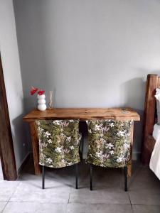 a wooden table with a pair of chairs in a room at Armazém do Porto, Chalé Azaléia in Morretes