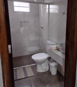 a bathroom with a toilet and a shower and a sink at Armazém do Porto, Chalé Azaléia in Morretes +18 photos