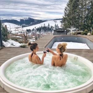 two women are sitting in a jacuzzi tub at Stara Pravda Hotel in Bukovel