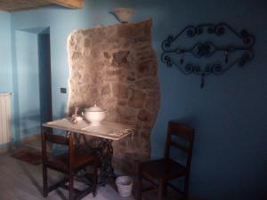 a table and chairs in a room with a stone wall at B&B Fiume Bianco in Fiumalbo