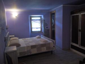 um quarto azul com uma cama e uma janela em B&B Fiume Bianco em Fiumalbo