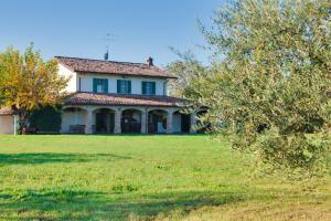 una casa vieja en un campo con un árbol en La Fattoria, en Santarcangelo di Romagna