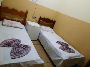 dos camas sentadas una al lado de la otra en una habitación en HOTEL TROPICAL, en Cuiabá