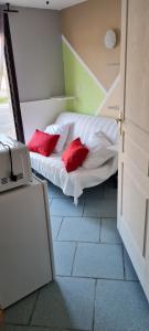 a bedroom with a bed with two red pillows at Auberge de l'Europe in Saint-Quentin-Fallavier
